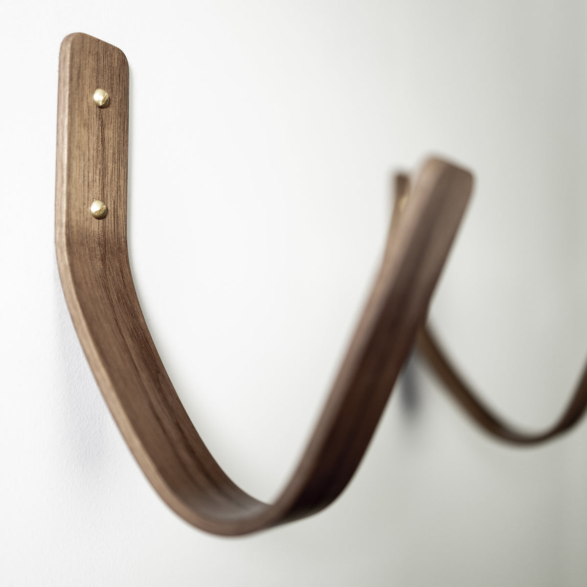 Close-up of premium walnut surfboard wall mount showing quality craftsmanship and board protection