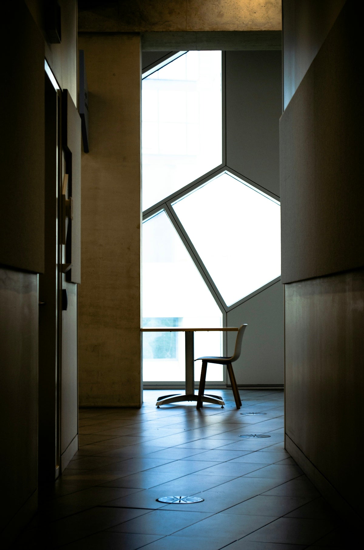 A table and chair near a geometric window