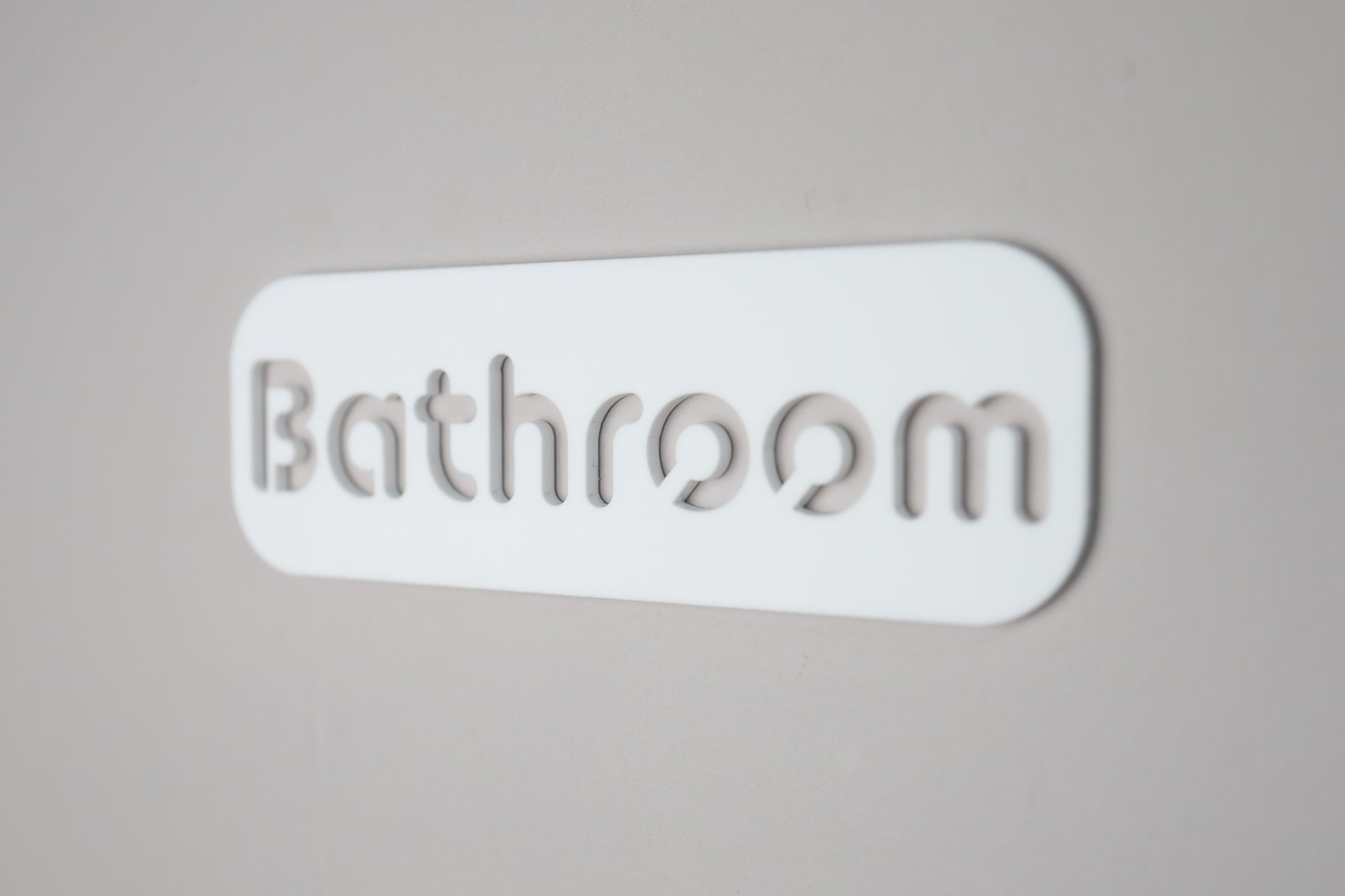 Elegant acrylic bathroom wall sign with cut-out letters and sleek black finish