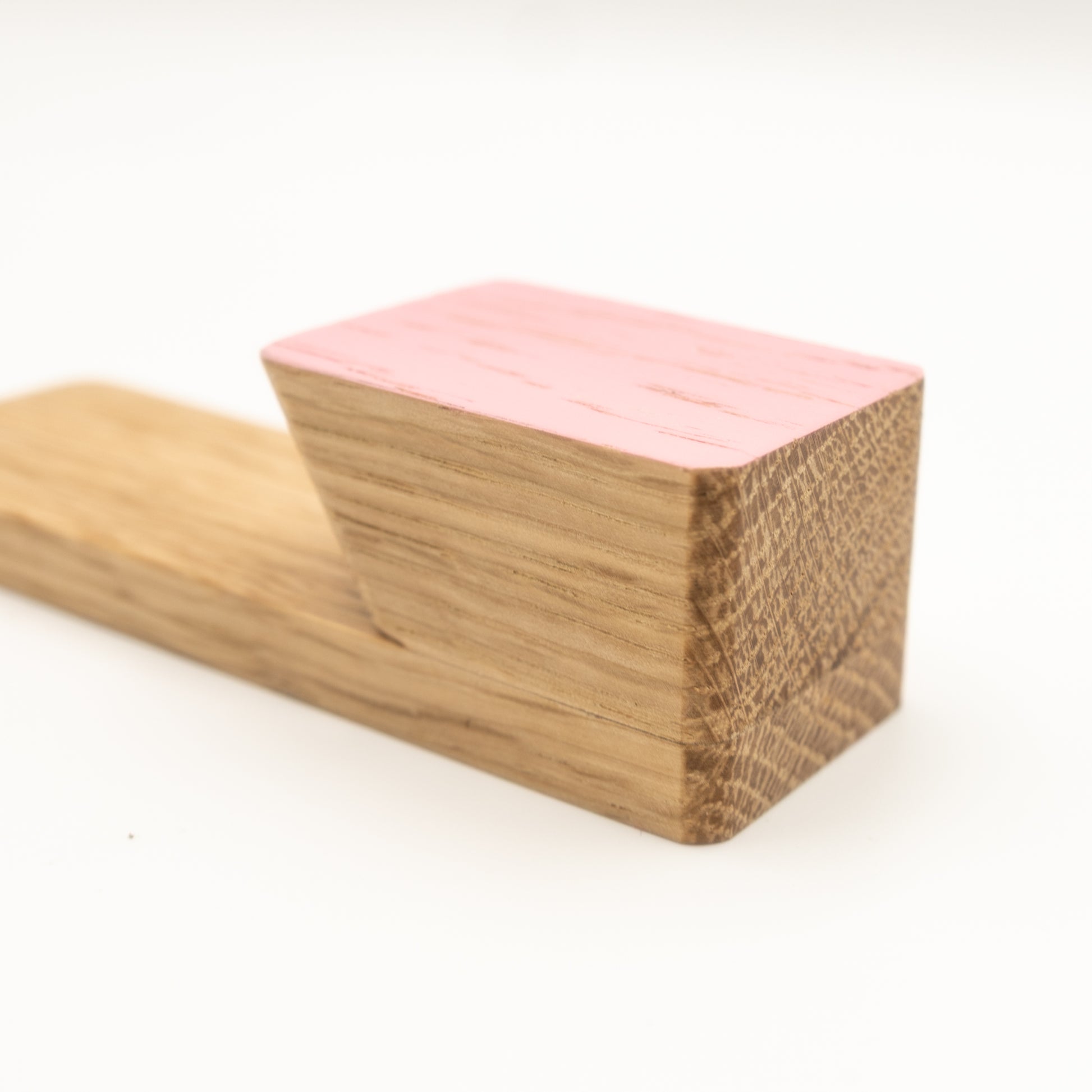 Two wooden blocks, one pink and one brown, on a white background