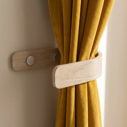 Wooden curtain tieback holding a yellow curtain against a beige wall.