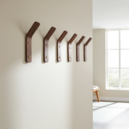 Set of wooden wall hooks on a neutral wall with a window in the background